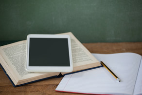 Tablet, Heft und Buch auf einem Tisch Ein Tablet, ein Buch und ein Heft liegen auf einem Tisch
