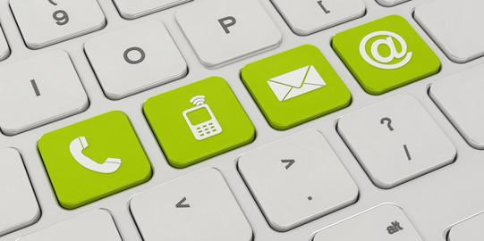 Kontakt Auf einer weißen Tastatur sind vier Tasten grün eingefärbt. Darauf zu sehen sind Symbole für ein Telefon, ein Mobiltelefon, ein Briefumschlag und ein "at"-Zeichen.